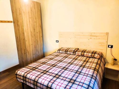 a bedroom with a bed with a checkered blanket at Pasubio 13 in Selvino