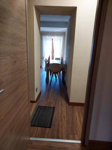 a hallway with a room with a table and a window at Pasubio 13 in Selvino