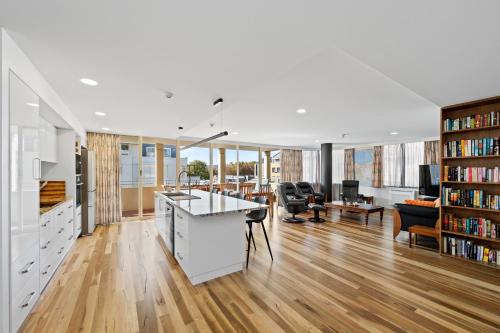 an open kitchen and living room with a book shelf at Jenatt Apartments Salamanca in Hobart