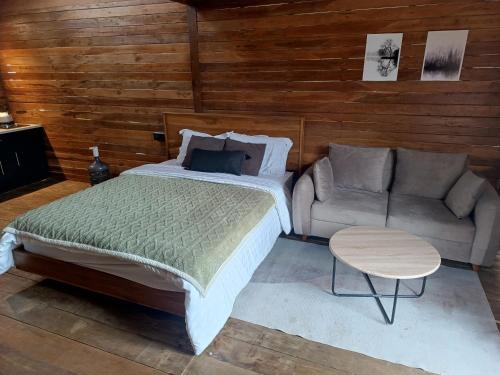 a bedroom with a large bed and a couch at Cabin atas awan in Dieng