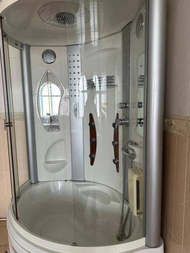 a shower with a glass door in a bathroom at Аренда Дома in Karakol