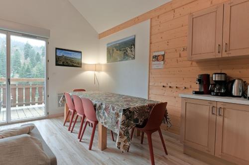 une cuisine avec une table et des chaises dans une pièce dans l'établissement Résidence récente au coeur des monts du Cantal, à Laveissière