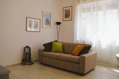 a living room with a brown couch with colorful pillows at La Casetta di via Tasso in Piombino