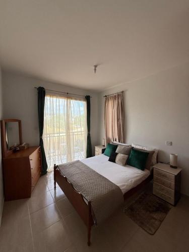 a bedroom with a large bed and a window at Unwind Kìśśornega - 2 Bedroom Apartment in Kissonerga