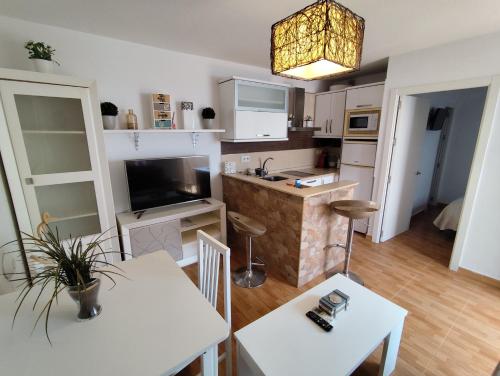 a kitchen with white cabinets and a table and chairs at El Refugio 2 Pax - WIFI in Tarifa