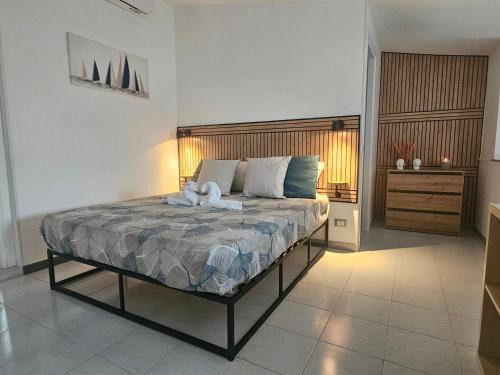 a bedroom with a bed with two stuffed animals on it at SolMarina Holiday House in Marina di Ragusa