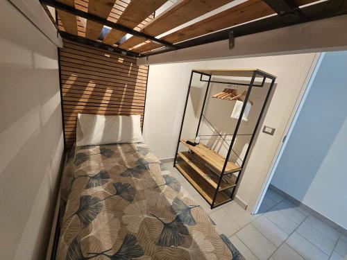 a small bedroom with a bed and a mirror at SolMarina Holiday House in Marina di Ragusa