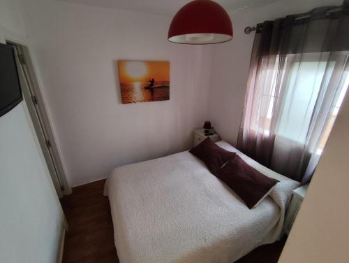 a bedroom with a bed and a painting on the wall at El Refugio 2 Pax - WIFI in Tarifa