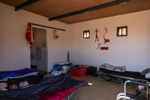 a room with three beds in a room with a wall at Spreetshoogte Campsite in Namibgrens