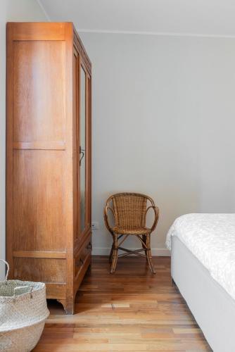 a bedroom with a dresser and a chair next to a bed at Cadenabbia Lake side Apartments in Griante Cadenabbia