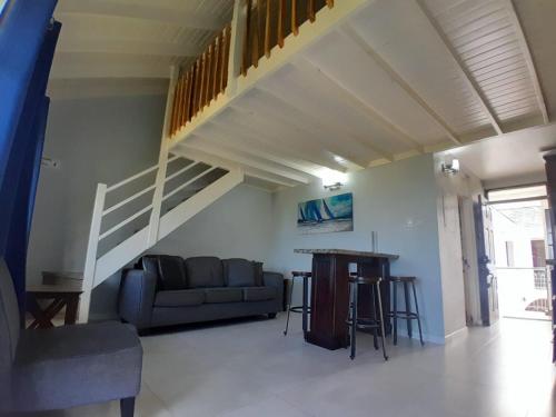 a living room with a couch and a staircase at Beautiful Beachview 2 Bebroom Loft at Sandcastles in Ocho Rios