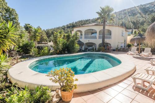 a swimming pool in front of a house at Sueño Grande in Lliber