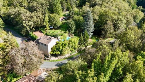 Vue aérienne d'une maison dans une forêt dans l'établissement La Papèterie chambres de charme, à Gavaudun