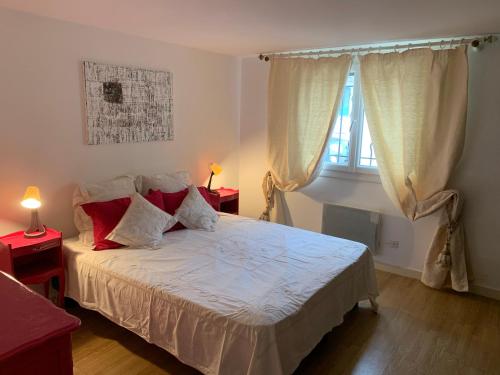 a bedroom with a bed with two tables and a window at T2 en rez-de-jardin en plein coeur de la Londe les Maures in La Londe-les-Maures