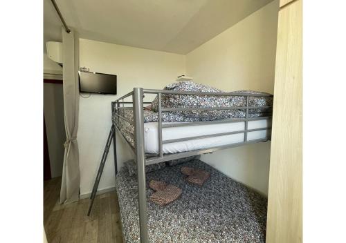 Ce lit superposé se trouve dans une petite chambre dotée d'une télévision. dans l'établissement Windy Barcarès 200 m de la mer, au Barcarès
