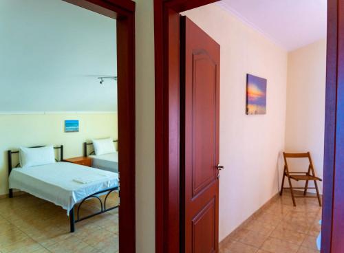 a door leading to a bedroom with a bed and a chair at Dina Apartments in Fanari