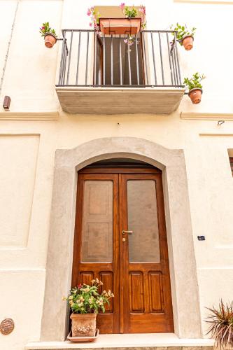 a building with a wooden door and a balcony at Il Borghetto in Gerace