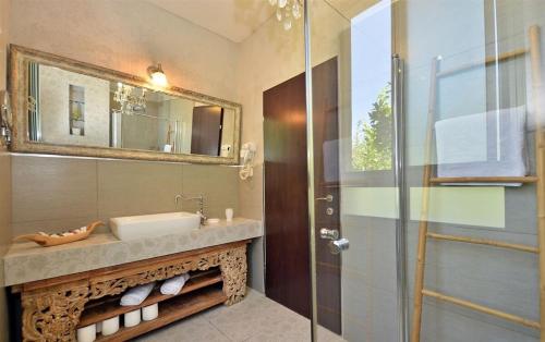 a bathroom with a sink and a mirror and a shower at אחוזת יוסף-וילה מהממת למשפחות עם 2 בריכות וג'קוזי in Hatzor haglilit