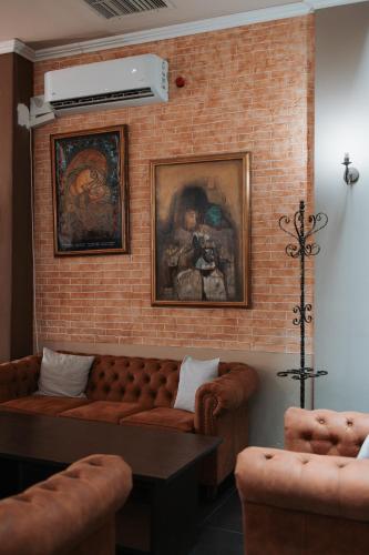 a living room with a couch and a brick wall at Hotel Neptun in Vidin