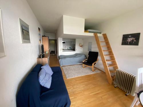 a living room with a blue couch and a bunk bed at Appartement mit Seeblick am Ossiacher See in Villach