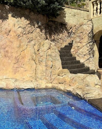 a swimming pool with a stairs and blue water at Villa La Mansion in Benissa
