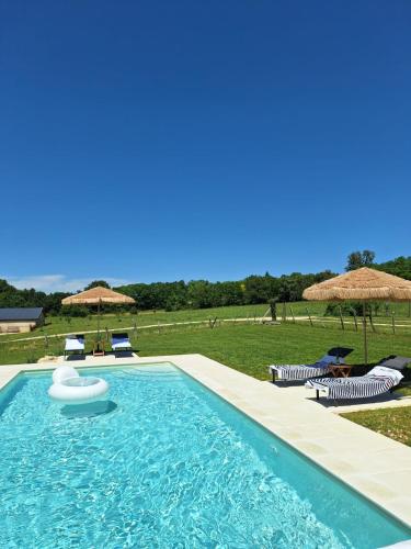 une piscine avec chaises et parasols dans l'établissement La Rapiette, à Payroux