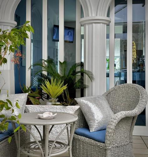 a patio with a wicker chair and a table at Hotel La Parigina in Lignano Sabbiadoro