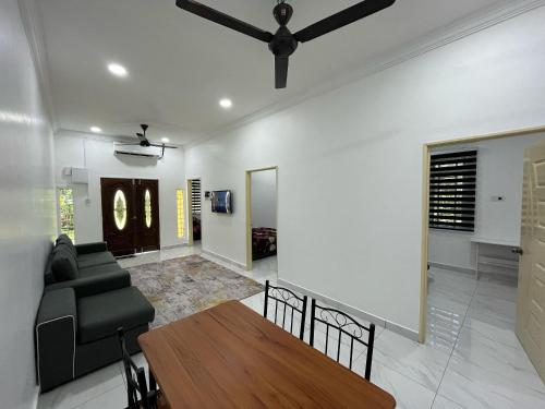 a living room with a ceiling fan and a table at Khayla Homestay Kuala Selangor in Kuala Selangor