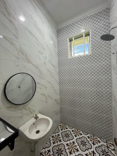 a white bathroom with a sink and a mirror at Khayla Homestay Kuala Selangor in Kuala Selangor