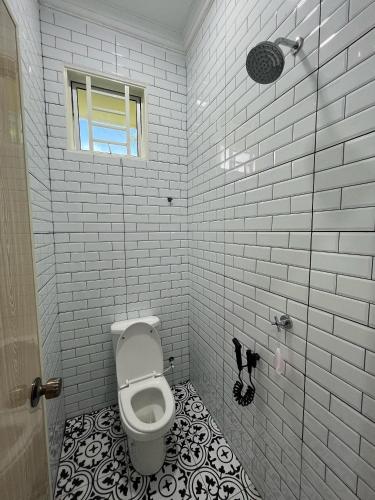a bathroom with a toilet and a window at Khayla Homestay Kuala Selangor in Kuala Selangor