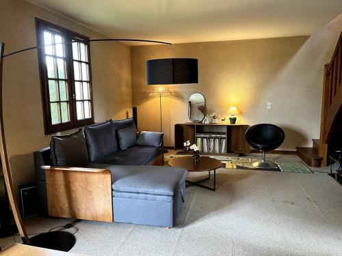 a living room with a couch and a table at Masion de la paix et nature in Saint-Maurice-lès-Charencey