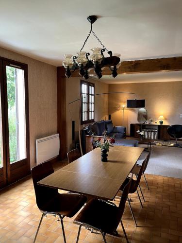 un salon avec une table et des chaises en bois dans l'établissement Masion de la paix et nature, à Saint-Maurice-les-Chérencey
