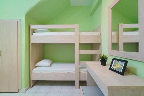 a room with bunk beds in a green room at Las sirenas maisonnettes by the beach groundfloor and semi basement in Chrysi Ammoudia