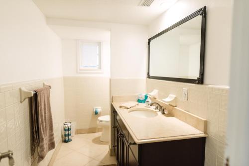 a bathroom with a sink and a mirror and a toilet at Golden Sands Pearl - Florida's Top - ALL Private Beachfront with NEW Pickleball Court, Pool, Spa in Indialantic