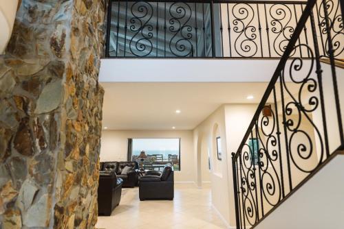 a staircase in a house with a stone wall at Golden Sands Pearl - Florida's Top - ALL Private Beachfront with NEW Pickleball Court, Pool, Spa in Indialantic