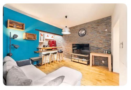 - un salon avec un canapé blanc et un mur en briques dans l'établissement LE PATIO de PROVENCE en AVIGNON - hypercentre, clim, WIFI, calme, à Avignon