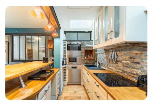 une cuisine avec des armoires blanches et des comptoirs en bois dans l'établissement LE PATIO de PROVENCE en AVIGNON - hypercentre, clim, WIFI, calme, à Avignon