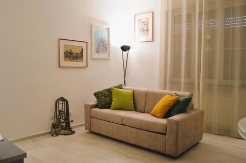 a living room with a couch with yellow and green pillows at La Casetta di via Tasso in Piombino