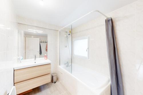 une salle de bain blanche avec un lavabo et une douche dans l'établissement Laharie - CI - PB - Triplex 118m2 avec grande terrasse et parking, à Bayonne