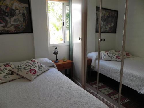 a bedroom with two beds and a mirror at Apartamentos Ana in Tazacorte