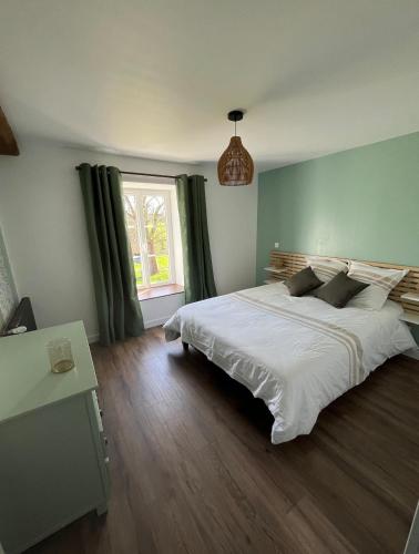 une chambre avec un grand lit blanc et une fenêtre dans l'établissement Détente à la campagne, à Chevry