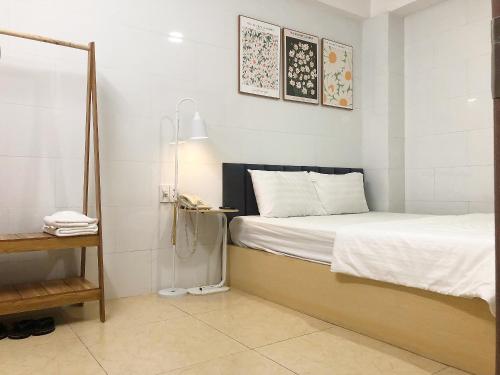a bedroom with a bed with a lamp and a phone at Thiên Quốc Hotel in Ho Chi Minh City