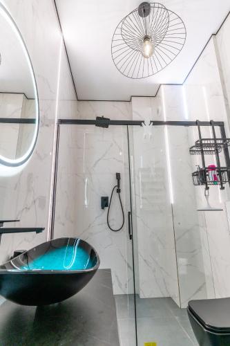 a bathroom with a black tub and a shower at Apartament Ostróda in Ostróda