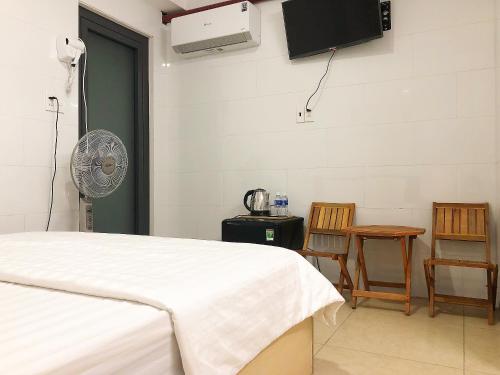 a bedroom with a bed and a fan and a table at Thiên Quốc Hotel in Ho Chi Minh City