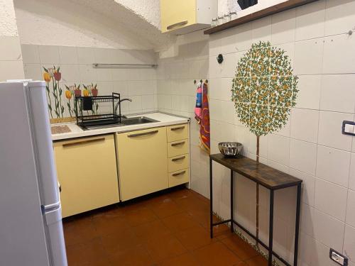 a kitchen with yellow cabinets and a table in it at La Comoedia in Amelia