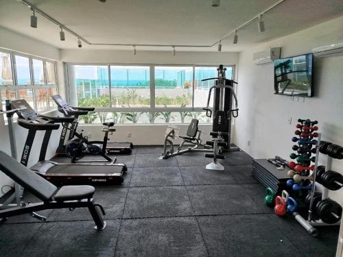 a gym with cardio equipment and a large window at Hoa Beach Flats Tamandaré - 210 in Tamandaré