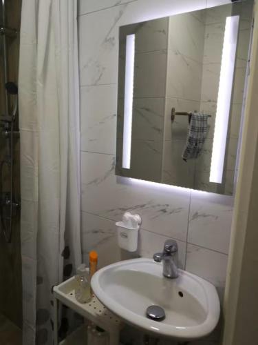 a white bathroom with a sink and a mirror at SKP-091 a&b in Skopje