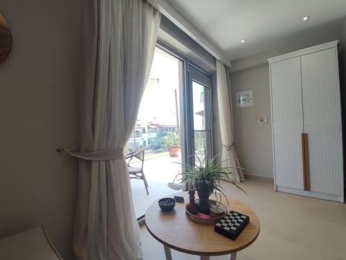 a living room with a table and a large window at Theros Summer Suite 2 in Nikiti