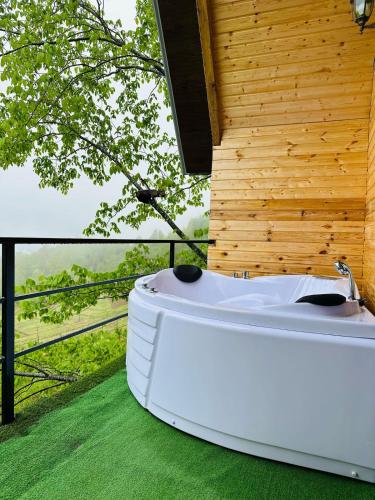 a white bath tub sitting on top of green grass at cottage panorama merisi in Inasharidzeebi
