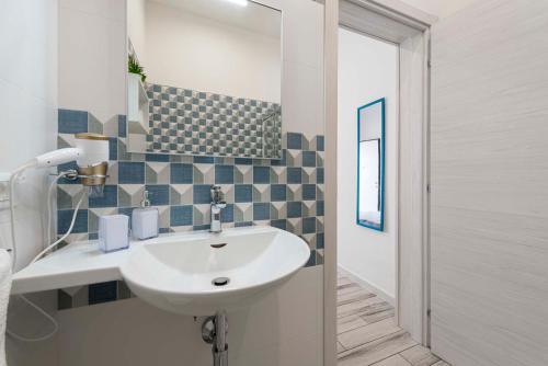 a bathroom with a white sink and a mirror at La Casodda B&B by La tua Puglia in San Pietro in Bevagna